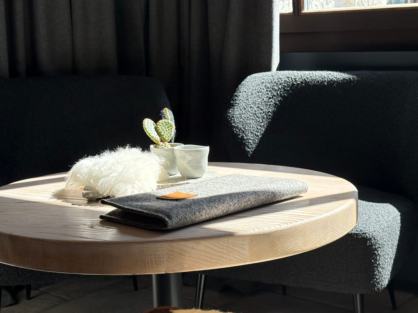 Sitzecke mit rundem Tisch, Schaffell und Kaktus-Deko – MONTAFONLodge