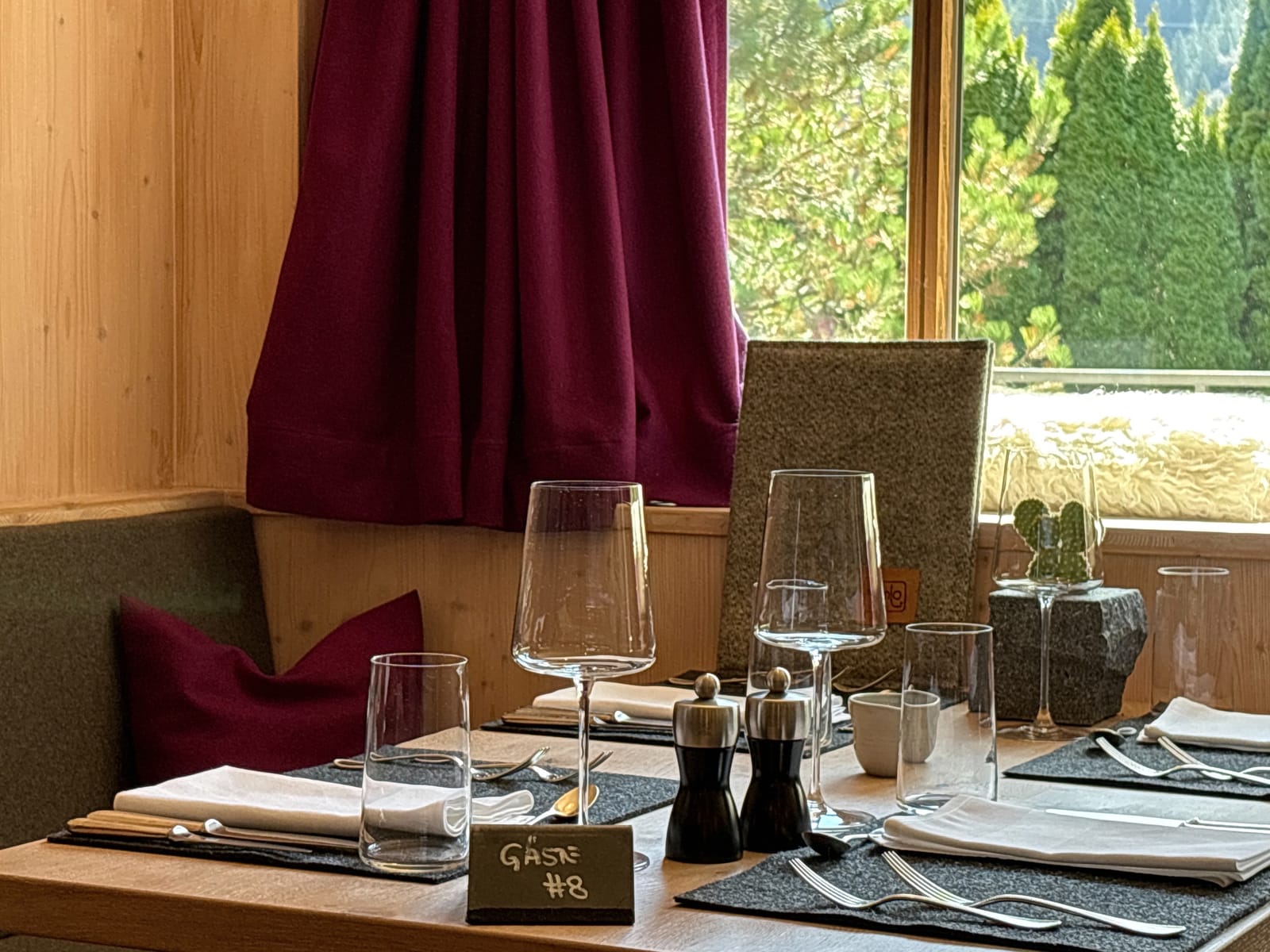 Gedeckter Tisch am Fenster mit Weingläsern (Variante) – MONTAFONLodge