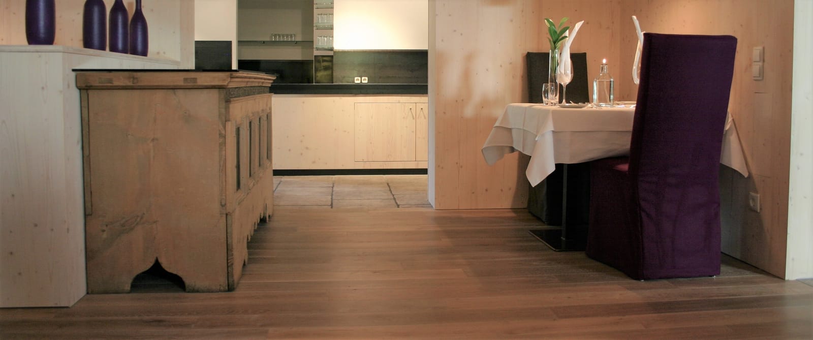 Restaurant-Raum mit Küchenzeile und eingedecktem Tisch – MONTAFONLodge
