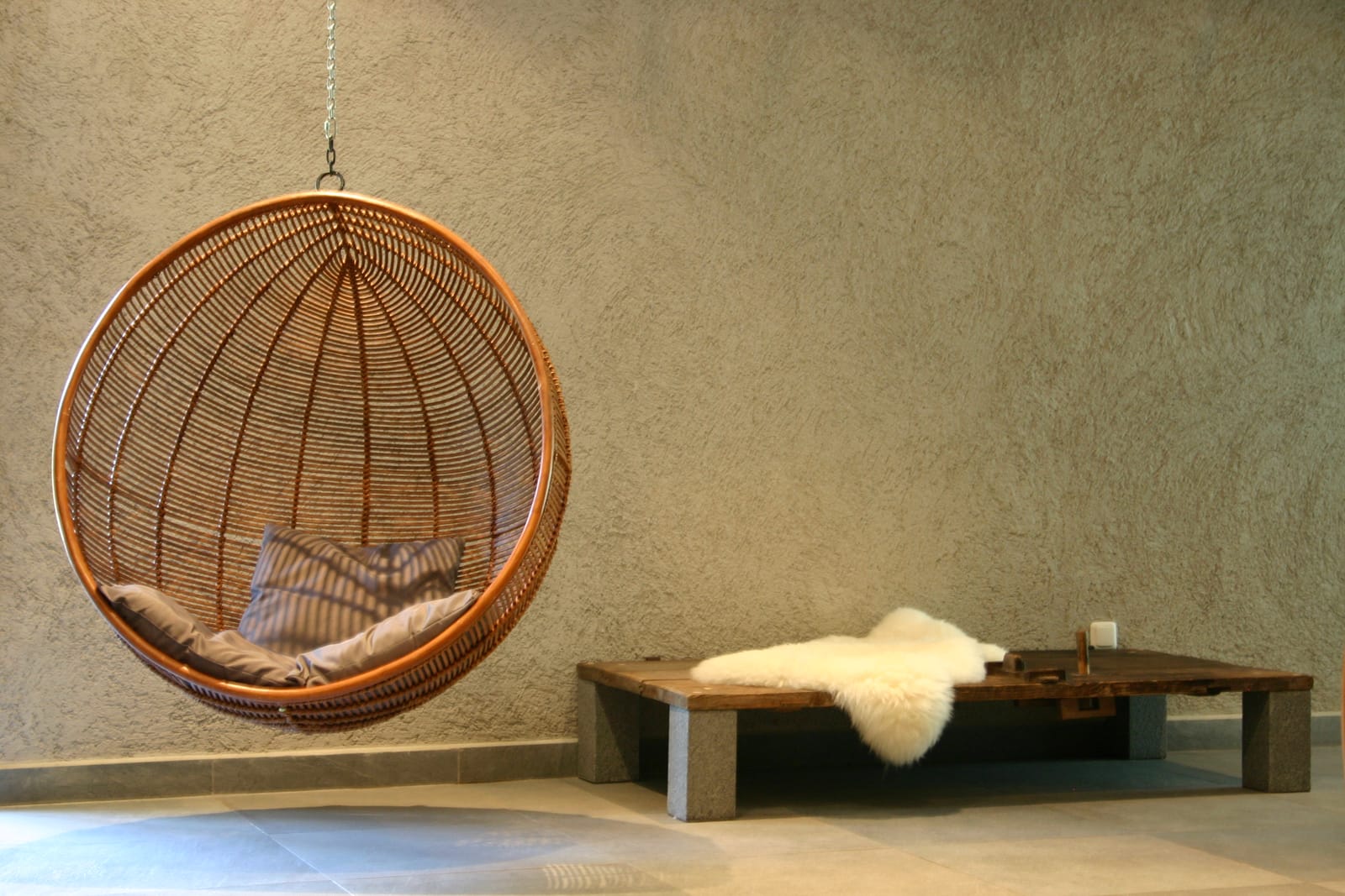 Rattan-Hängesessel mit Schaffell und Bank – MONTAFONLodge