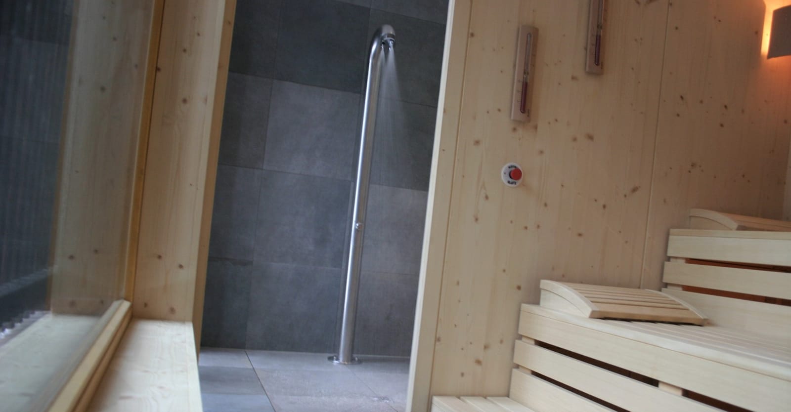 Dusche mit Holzverkleidung im Sauna-Vorraum – MONTAFONLodge