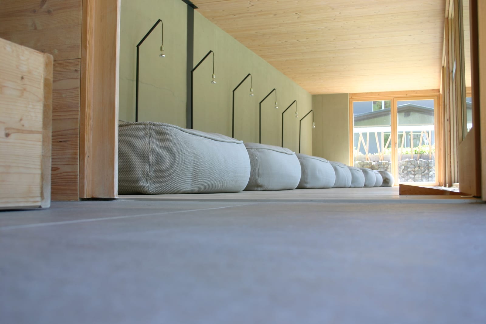 Ruheraum mit Liegen unter Dachschräge am Fenster – MONTAFONLodge