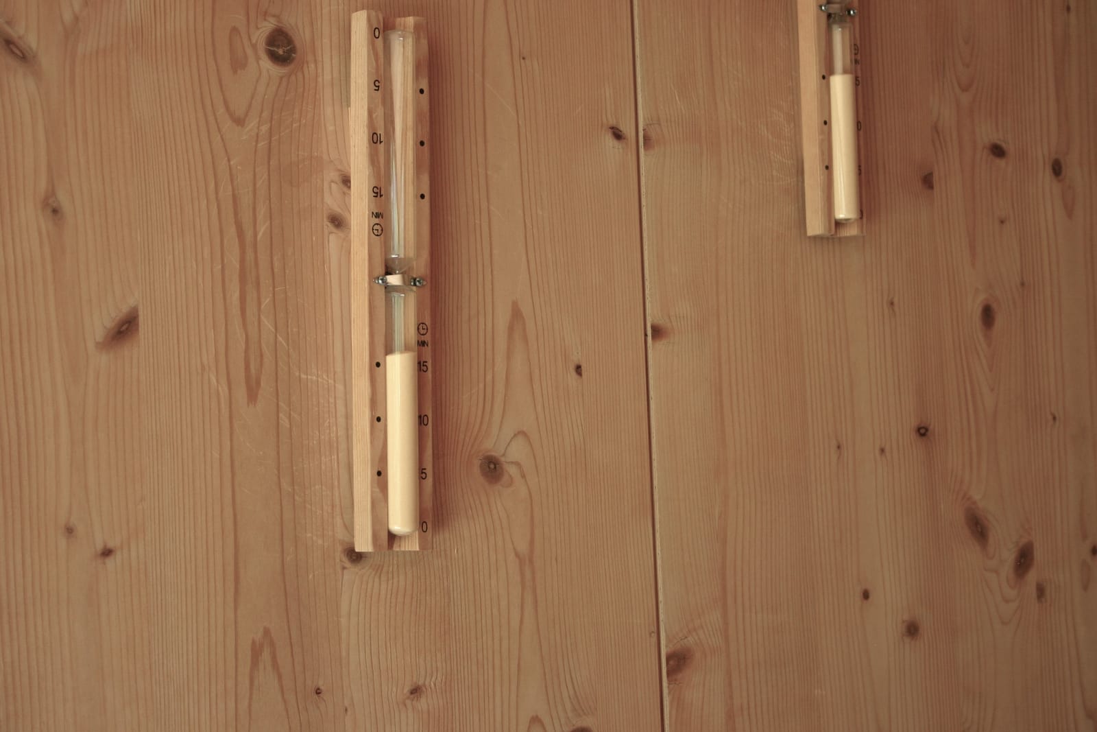 Sauna-Holzwand mit Sanduhr und Thermometer, Detail – MONTAFONLodge