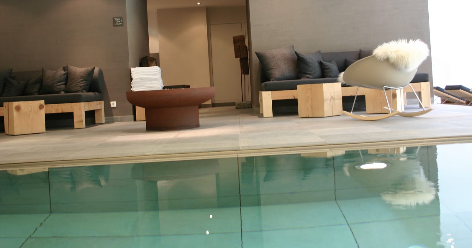Ruheliegen mit Kissen und Schaffell am Innenpool – MONTAFONLodge