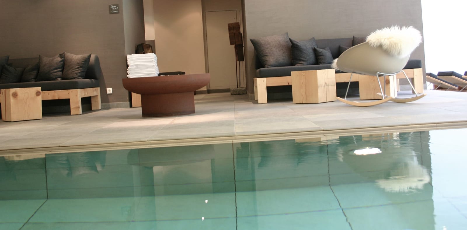 Ruhebereich mit Liegen und Schaffell am Innenpool – MONTAFONLodge