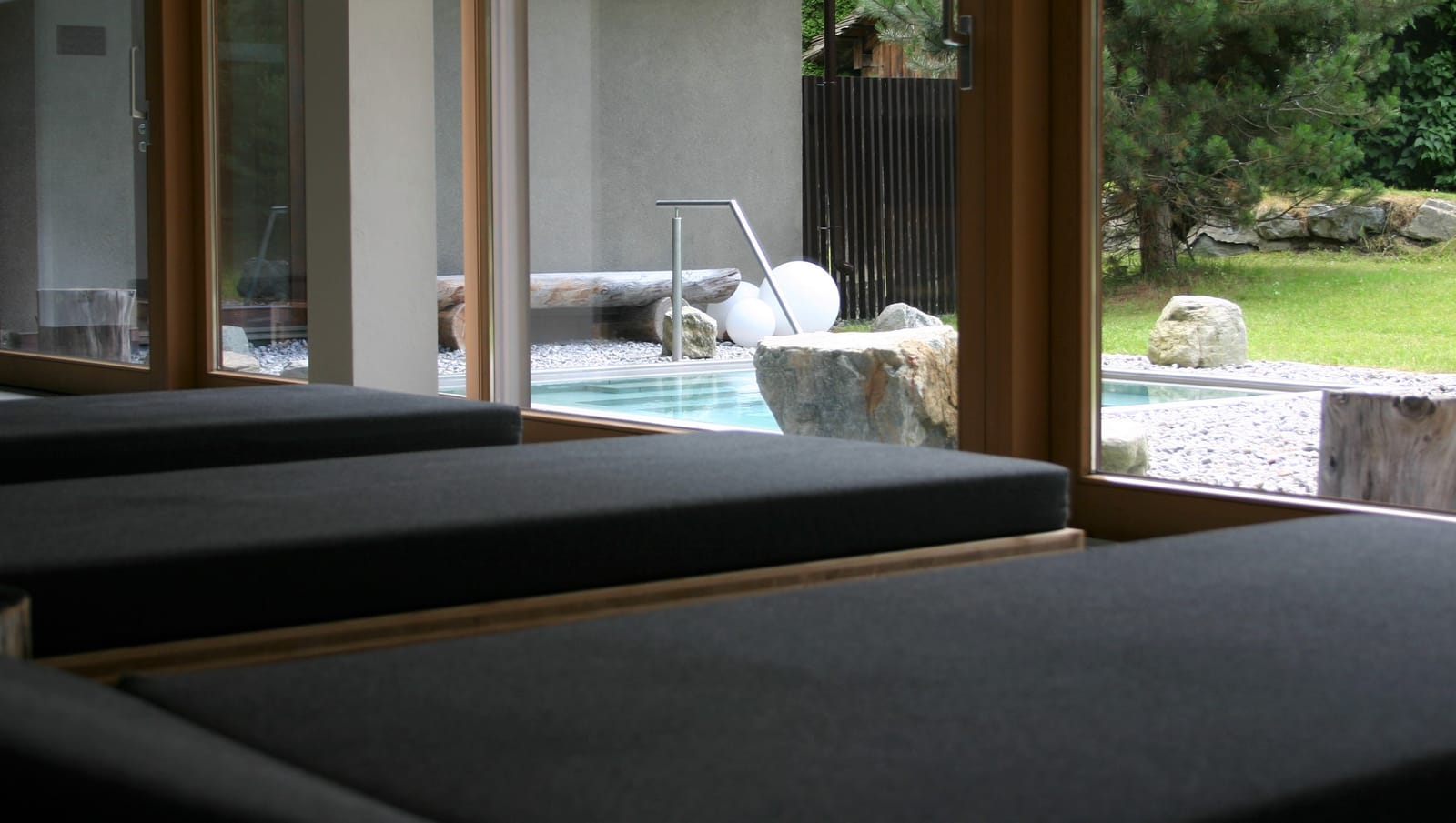 Ruheliege am Fenster mit Blick zum Außenpool – MONTAFONLodge