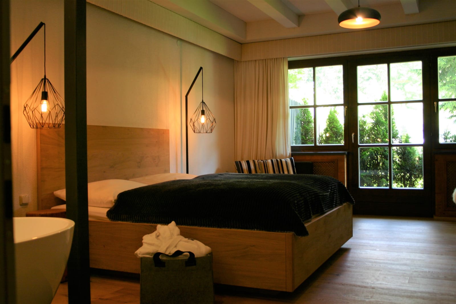 Doppelbett mit Balkontür, Pendelleuchten und Deko-Taschen – MONTAFONLodge