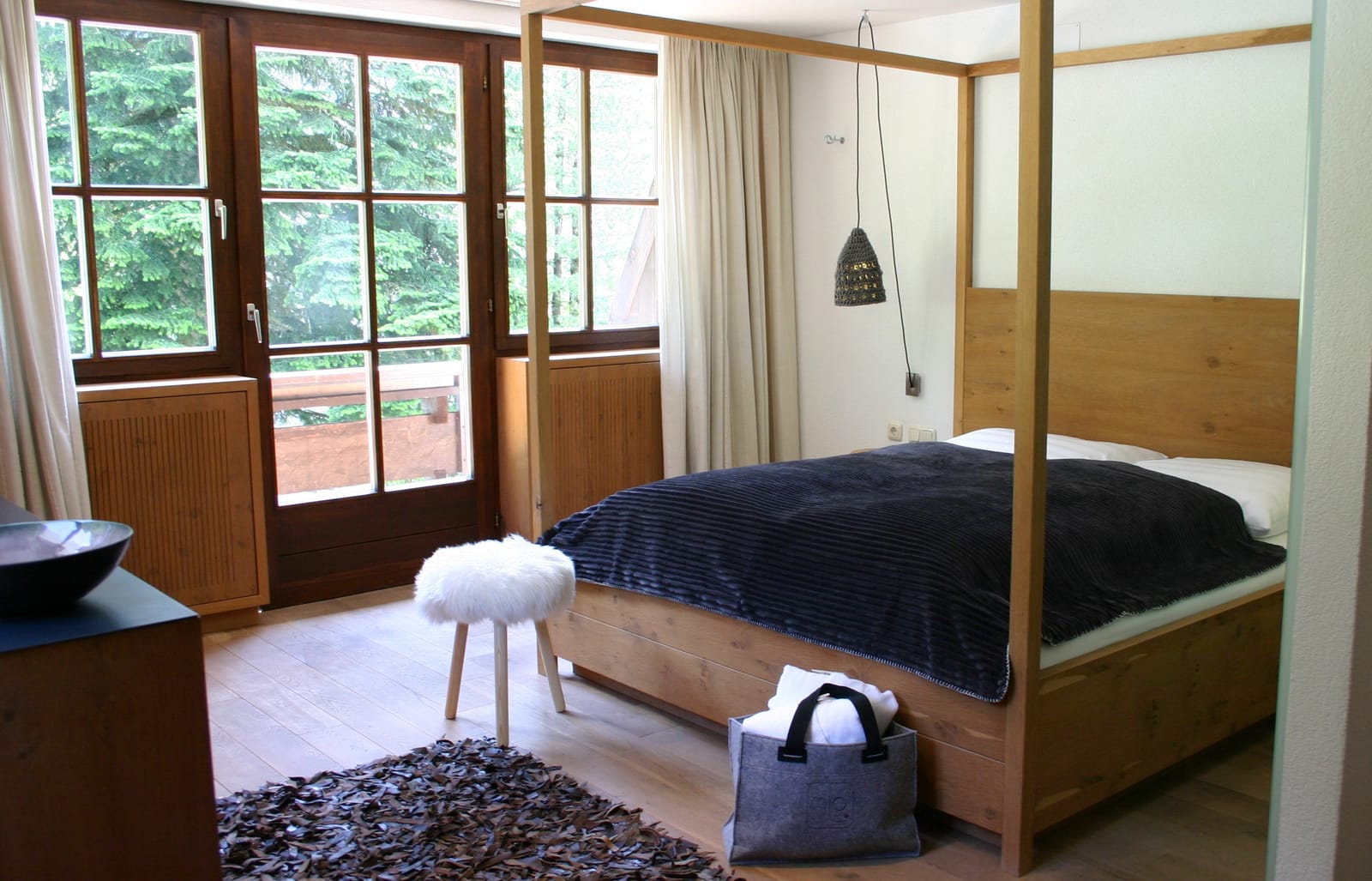 Holz-Himmelbett mit Balkontür, Fellteppich und Deko-Tasche – MONTAFONLodge