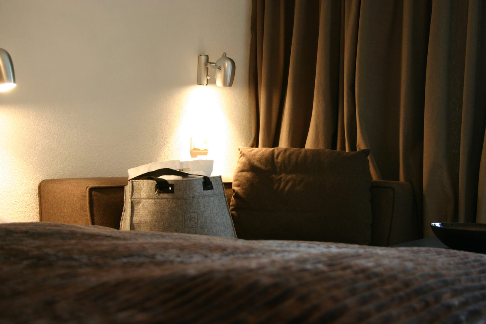 Bett mit Nachttisch-Leseleuchte, Vorhang und Sessel-Ecke – MONTAFONLodge