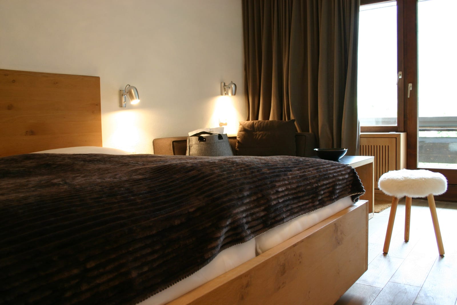 Doppelbett mit Wandleuchten, Nachttischen und Vorhängen – MONTAFONLodge