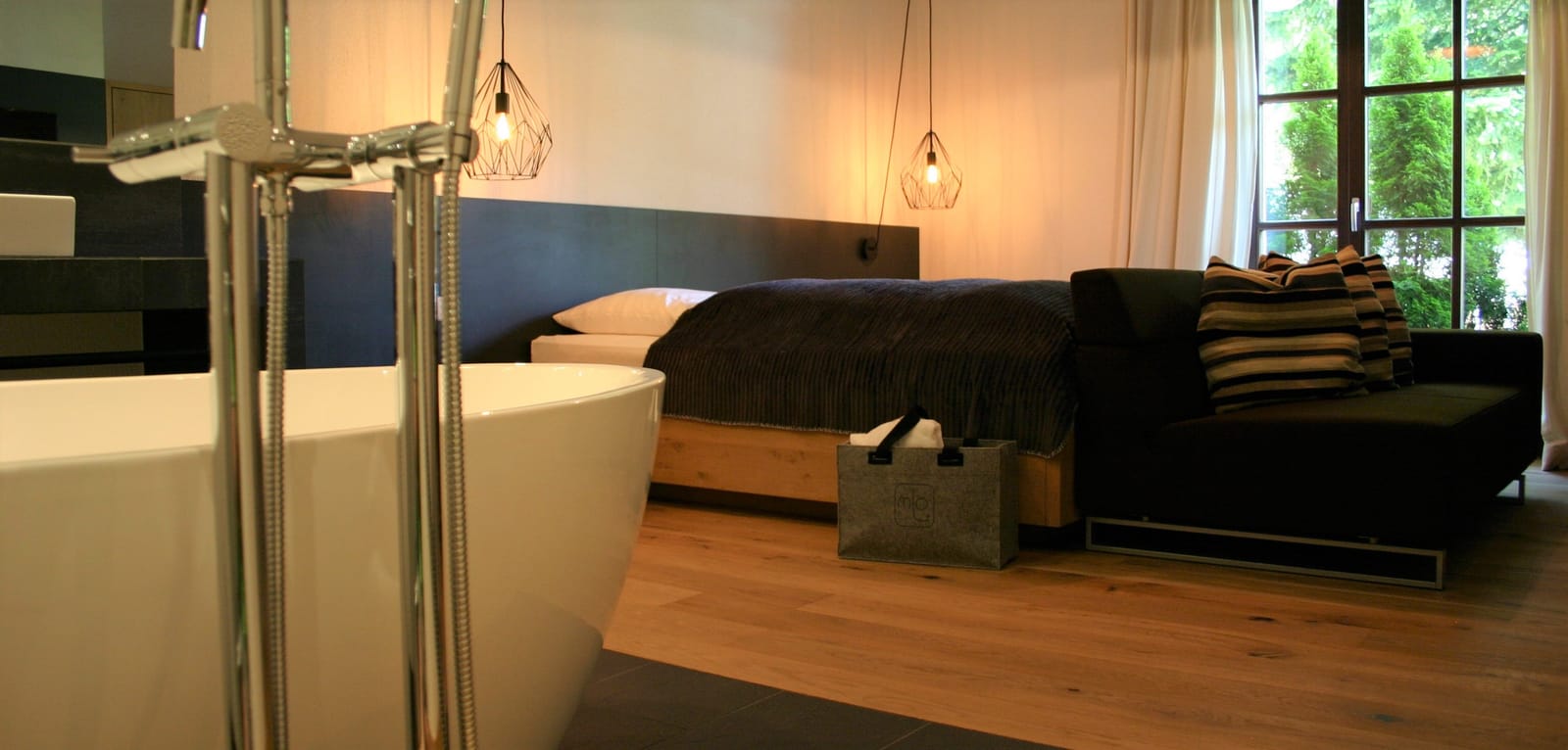 Freistehende Badewanne mit Bett und Pendelleuchte – MONTAFONLodge