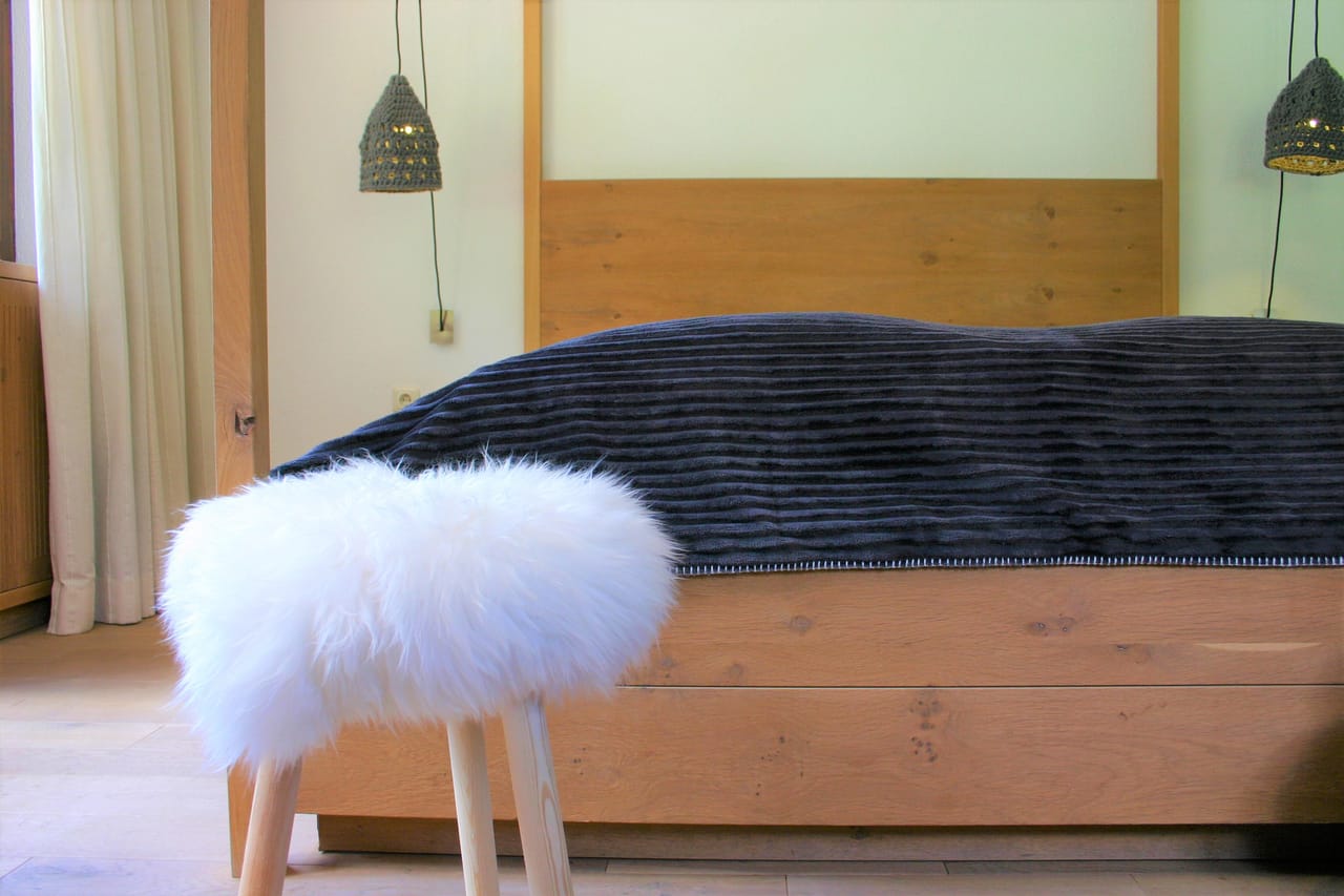 Large Doppelzimmer der MONTAFONLodge mit Doppelbett, Teppich und großen Fenstern