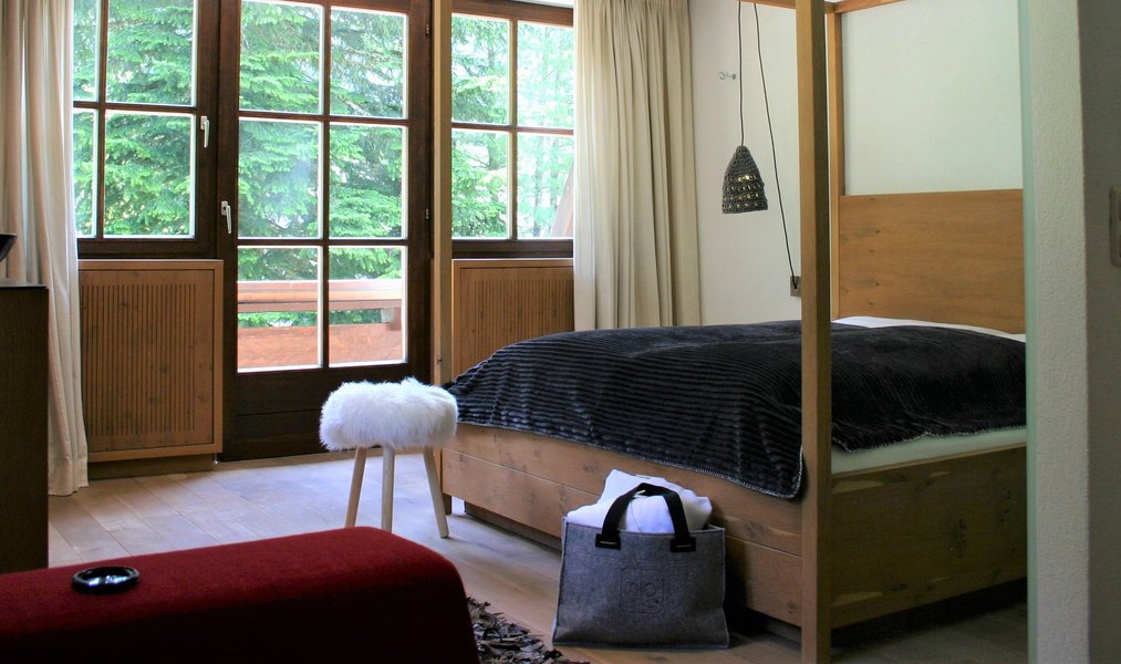 Bed with balcony door and forest view, MONTAFONLodge